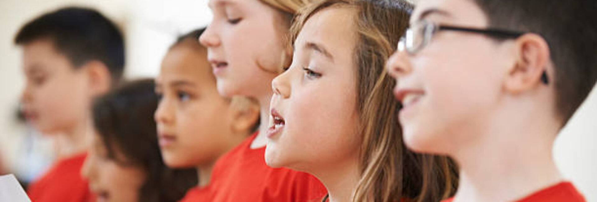 Group Of School Children Singing In Choir Together