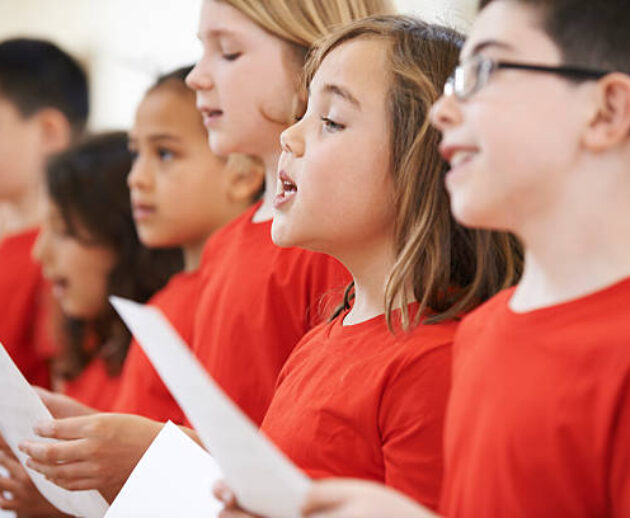 Group Of School Children Singing In Choir Together
